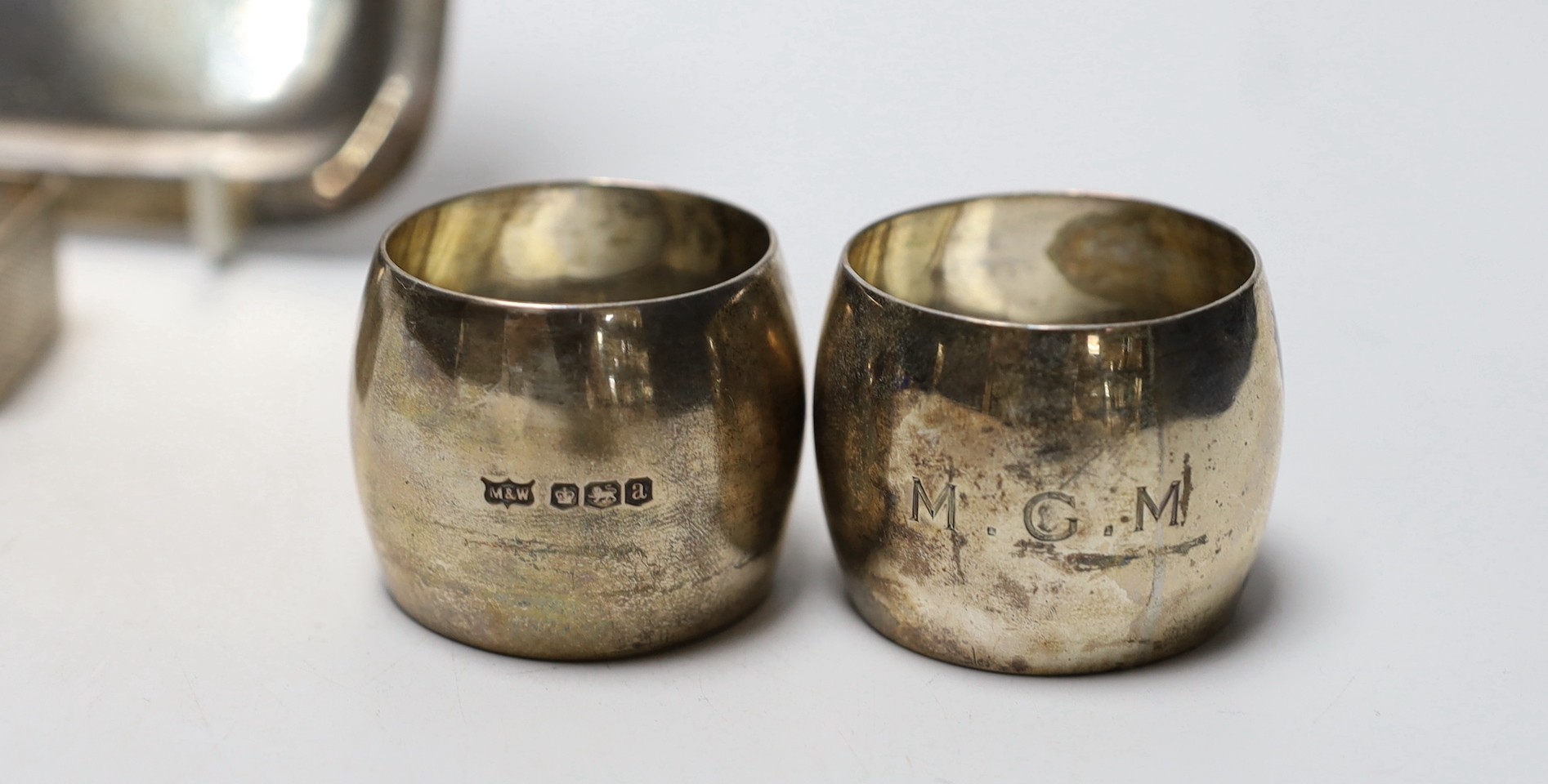 A George V small square silver dish by James Dixon & Sons and three silver napkin rings.